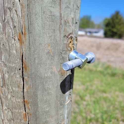 Photo shows the backside of a wooden fence post using Bullet Fence System&#39;s wood brace kit. 