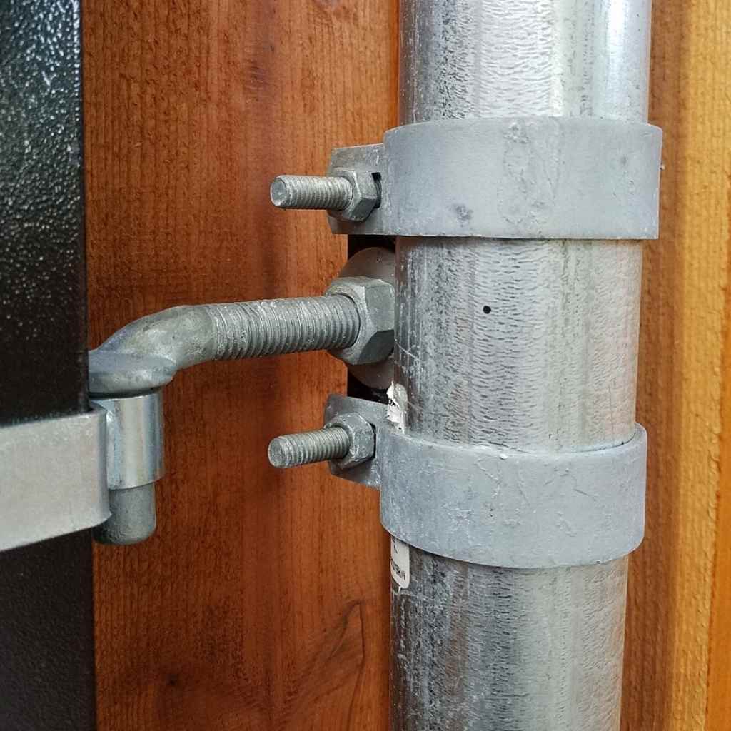 Bullet Fence Systems one-way gate hinge installed on residential fence - close up 